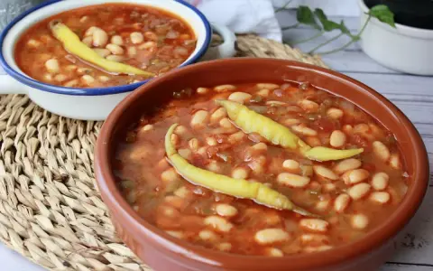 Dos cuencos de pochas a la navarra, un plato reconfortante con judías blancas, tomate y pimientos.