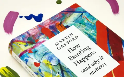 A book titled "How Painting Happens" by Martin Gayford, featuring a vibrant, abstract cover that evokes the spirit of figurative painting. Splatters of paint surround it.