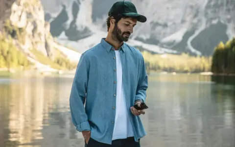 Un homme porte une chemise en tissu léger, parfaite pour une journée en plein air au bord d'un lac.