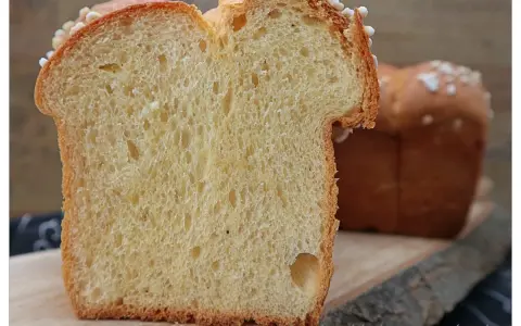 Schnitt von einem goldbraunen Brioche-Brot, perfekt für Lievito Madre Rezepte. Die weiche Krume mit kleinen Luftlöchern und die süße Kruste laden zum Genuss ein.