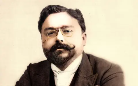 Portret kompozytora Isaaca Albéniza w okularach i z wąsami.