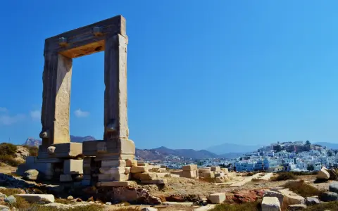 Antica porta a Naxos, con la città bianca sullo sfondo. Un luogo perfetto per esplorare con i bambini.