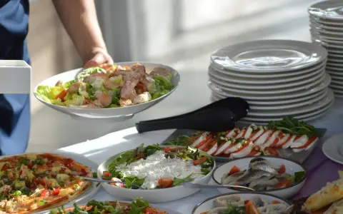 Na stole bufetowym z pizzą, sałatkami i śledziami, dowiedz się, jakie są zasady korzystania z "open baru" i bufetów tematycznych.