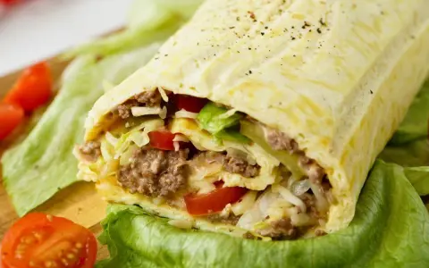 Herzhafte Big Mac Rolle gefüllt mit Hackfleisch, Salat, Tomaten und Käse, serviert auf knackigem Salatblatt.