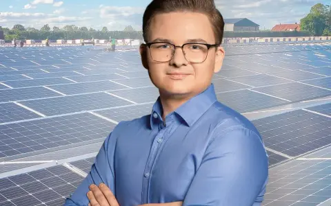 Mężczyzna w okularach na tle farmy fotowoltaicznej. Szanuj energię, nie daj się oszustom.