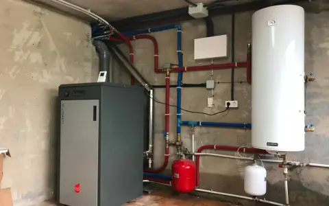 Instalación de caldera de pellets para radiadores, con depósito de agua caliente y sistema de tuberías.