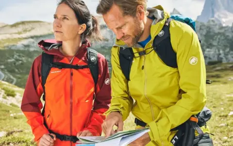 Wanderer prüfen die Route. Ihre wasserdichten Jacken schützen sie vor dem Wetter.