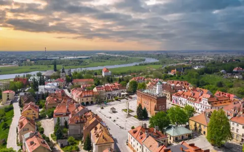Urokliwy rynek i rzeka w miasto zakochanych w Polsce. Dachy kamienic i zieleń tworzą malowniczy krajobraz.