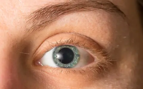 Occhio con iride azzurra e pupille dilatate, forse per l'emozione o la poca luce.