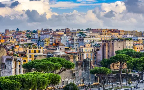 Vista panorámica de Roma con edificios históricos y pinos. Jóvenes exploran la ciudad eterna, disfrutando de su belleza.