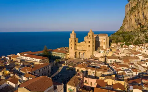 Cefalù cosa vedere: la maestosa Cattedrale Normanna domina il borgo con le sue torri, incastonata tra il mare blu e la rocca imponente.