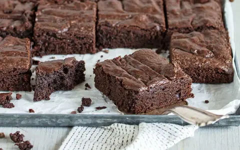 Saftige Schokoladen-Brownies, perfekt für jedes Brownie Rezept. Ein Stück wird gerade herausgehoben.