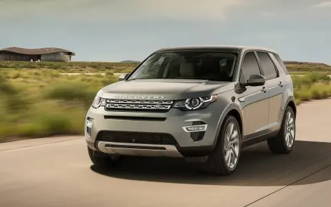 Szary Land Rover Discovery Sport w ruchu, z widocznym napisem "DISCOVERY". Czyżby kolejne awarie?