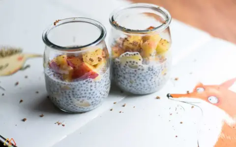 Dwa słoiczki z puddingiem chia i owocami. Pyszny sposób na nasiona chia jak jeść.