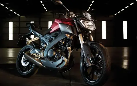 Czerwono-szary motocykl Yamaha TZR 125 V-Max w ciemnym pomieszczeniu.