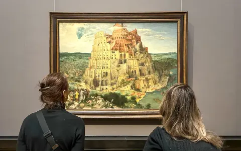 Dwie osoby oglądają obraz Wieża Babel w Muzeum Historii Sztuki w Wiedniu.