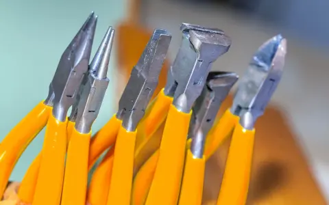 Variedad de tipos de alicate con mangos naranjas, listos para cualquier tarea de bricolaje o joyería.