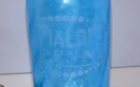 Bouteille ancienne en verre bleu pour eau de seltz, gravée "EAUX DE PENNES". Un objet de collection qui évoque le prix d'une eau gazeuse d'antan.