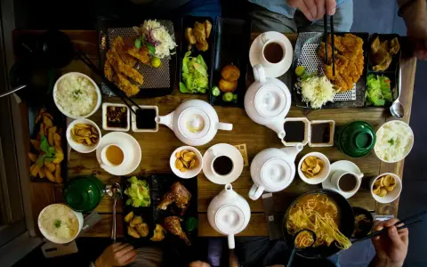 Mesa llena de platos asiáticos, teteras y tazas. Una experiencia culinaria en un restaurante sensorial.