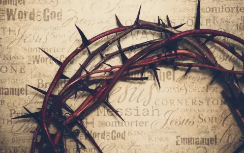 Dornenkrone auf Pergament mit Titeln wie "Jesus", "Messiah", "Savior". Sie symbolisiert die tiefe Jesus Christus Bedeutung und sein Leiden.