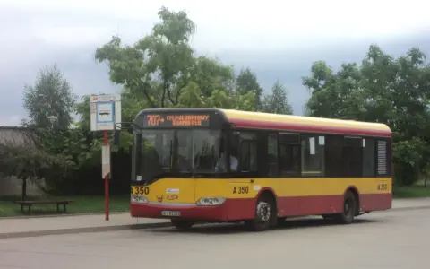 Autobus 707 z napisem "CM. POŁUDNIOWY BRAMA PŁD." czeka na pasażerów. Rozkład jazdy jest widoczny na przystanku.