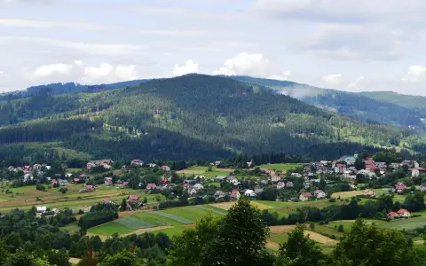 Letnia panorama Istebnej z górami i domkami. Idealne miejsce na wakacje, pełne atrakcji.