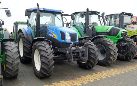 Rząd nowoczesnych traktorów: niebieski New Holland, zielony Deutz-Fahr i żółty Claas. Zastanawiasz się, ile motogodzin to dużo dla takiej maszyny?