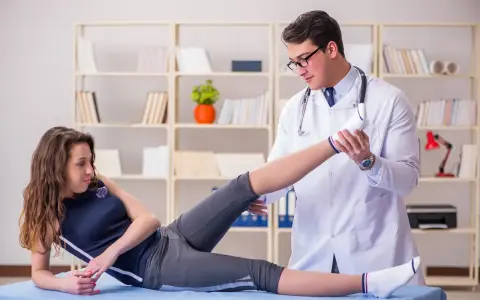 Fizjoterapeuta bada nogę pacjentki. Dowiedz się, jak zostać fizjoterapeutą i pomagać w powrocie do zdrowia.