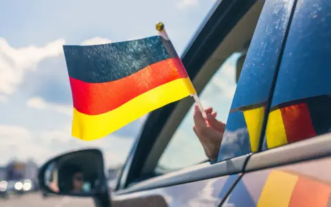 Niemiecka flaga powiewa z okna samochodu. To jak raport TUV z podróży, pełen dumy i radości.