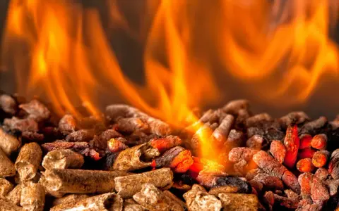 Fiamme arancioni danzano su un letto di pellet ardente. Per scaldare 100 mq, quanti kw servono?