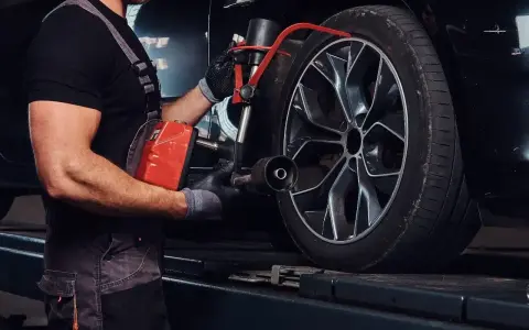 Mechanik sprawdza opony Kormoran, zastanawiając się, gdzie produkowane są te solidne opony.