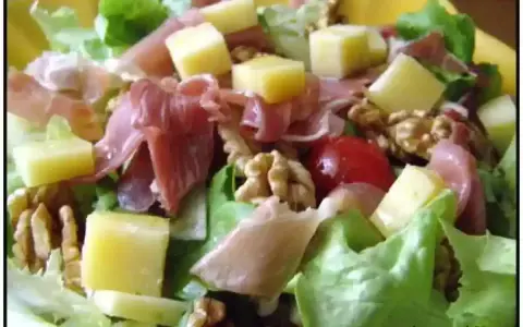 Salade fraîche avec jambon cru, dés de fromage, noix et tomates cerises. Une belle entrée auvergnate pour un repas léger.