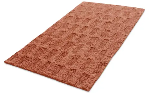 En mjuk, orange badrumsmatta med ett rutmönster. Den ger en varm och inbjudande känsla.