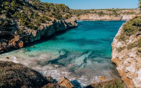 Cala des Moro, Majorka. Turkusowa woda obmywa skaliste wybrzeże, tworząc malowniczą zatoczkę.