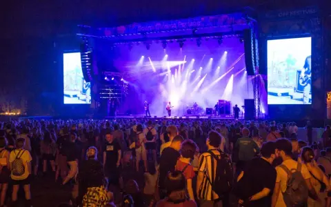 Tłum ludzi na koncercie OFF Festival 2026. Na scenie zespół w świetle reflektorów, a obok wielki ekran z transmisją.