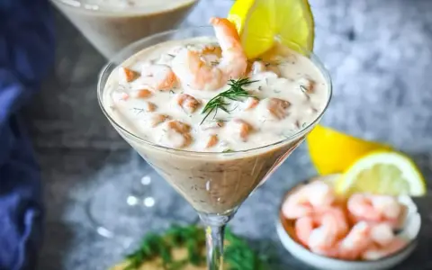 Ein cremiger Shrimp Cocktail in einem Martiniglas, garniert mit Dill und Zitrone. Ein köstlicher Genuss!