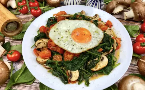 Herzhaftes Gericht mit Baby Spinat, Tomaten, Pilzen und Spiegelei. Perfekt für gesunde Baby Spinat Rezepte.
