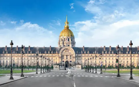 Imponente cúpula dorada del Hôtel des Invalides en París, con su fachada clásica y farolas a ambos lados de la avenida.