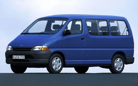 Niebieski van Toyota Hiace z lat 90. z widocznymi siedzeniami i oknami.