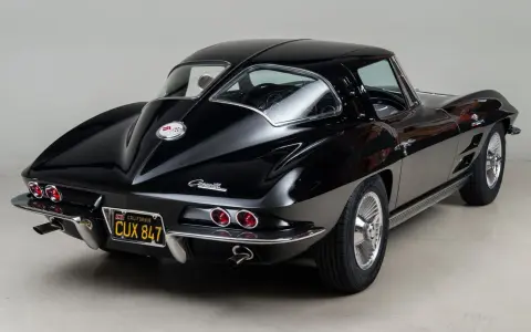 Un clásico Corvette Stingray negro, un ícono de los muscle cars americanos, con su distintiva silueta y detalles cromados.