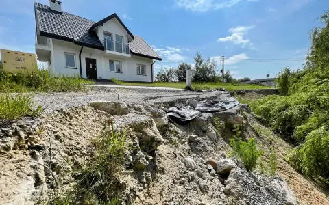 Nieaktywne osuwisko obok budowy domu. Teren niestabilny, droga częściowo zniszczona.