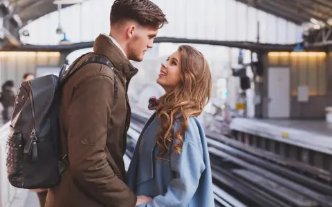 Un couple se regarde avec tendresse sur un quai de gare, un moment où l'on peut se sentir connecté à quelqu'un à distance.
