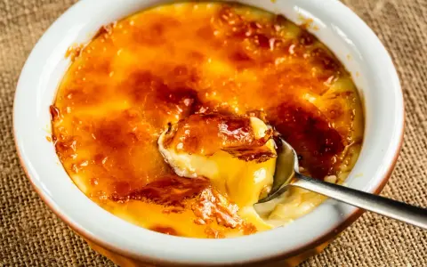Crème brûlée, un dessert iconique dont l'origine remonte au XVIIe siècle, avec sa croûte caramélisée craquante et sa crème onctueuse.