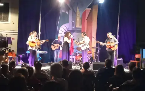 Concerto dal vivo con chitarre acustiche e voce, gli accordi di Bamboléo risuonano nell'aria.