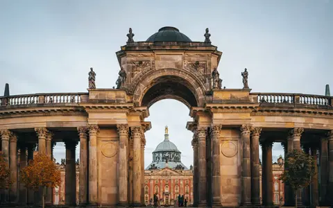 Prachtvoller Torbogen mit Blick auf das Neue Palais in Potsdam. Ein toller Ort, um zu entdecken, was man in Potsdam machen kann.