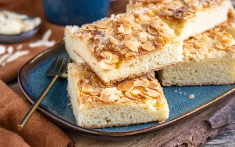Saftige Stücke Butterkuchen mit Mandelblättchen und Zucker bestreut, bereit zum Genießen. Ein köstliches Rezept für jeden Anlass.