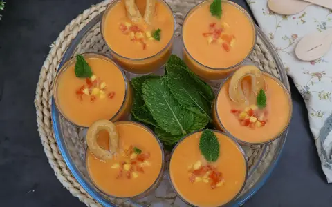 Gazpacho de mango en vasos con trocitos de mango, menta y picos.