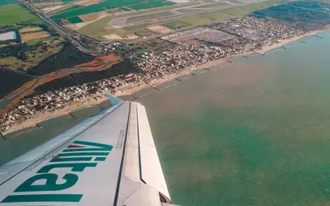 Widok z samolotu Alitalia na wybrzeże Włoch. Zastanawiasz się, ile się leci do Włoch?