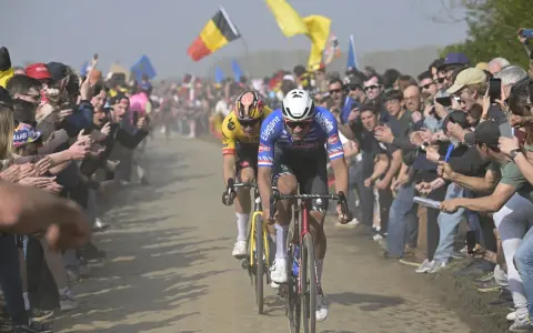 Zwei Radprofis kämpfen auf staubiger Strecke, umringt von jubelnden Fans. Die Spannung steigt, doch die Frage nach fairem Wettkampf und Doping im Radsport bleibt.