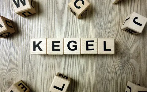Drewniane klocki z literami układają słowo "KEGEL". Ćwiczenia mięśni Kegla u kobiet to klucz do zdrowia.